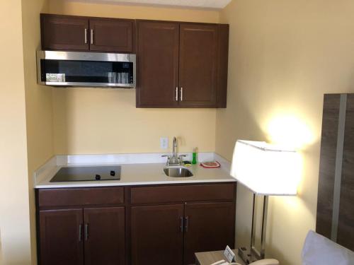 a kitchen with a sink and a microwave at Days Inn by Wyndham Cape Carteret in Cape Carteret