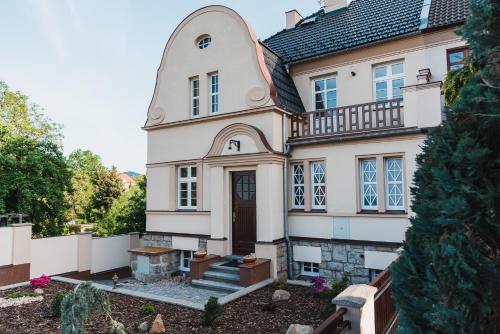 ein großes weißes Haus mit einem Turm in der Unterkunft Penzion U Pivovaru in Děčín