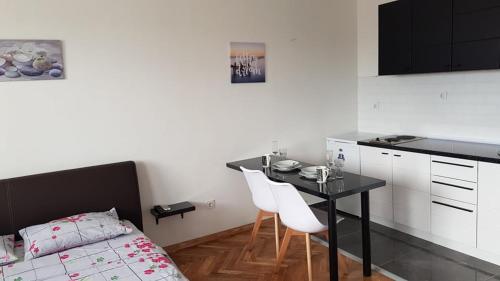 a bedroom with a table and a bed and a kitchen at CENTRAL VIEW APARTMENT in Skopje