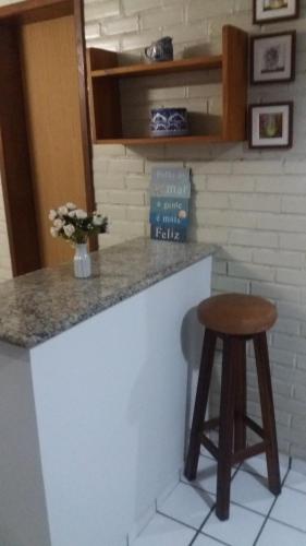 um balcão de cozinha com um banco e um balcão em Apto Aconchegante Enseada Azul com Wi-Fi em Guarapari