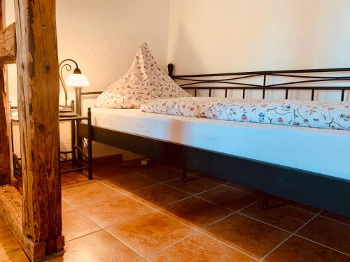 a bed in a room with a lamp and a table at Landhaus Tannenhof in Lind