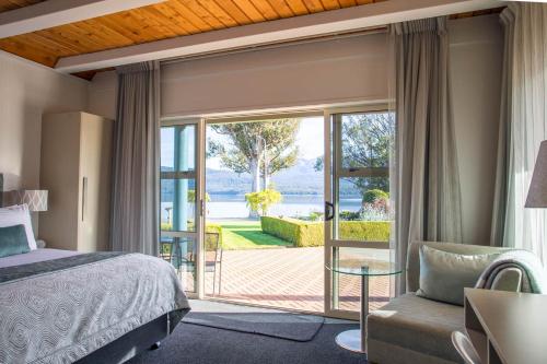 a bedroom with a bed and a sliding glass door at Radfords on the Lake in Te Anau