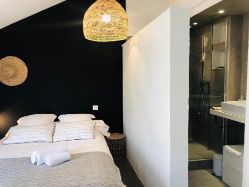 a bedroom with a bed and a black wall at Appartement Casaluna - Casadibastia - Vue mer Citadelle in Bastia