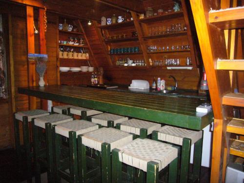 bar z zielonymi i białymi krzesłami w restauracji w obiekcie Chata pri potoku w Zuberzcu