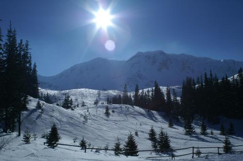 a sun shining over a snow covered mountain at Chata pri potoku in Zuberec