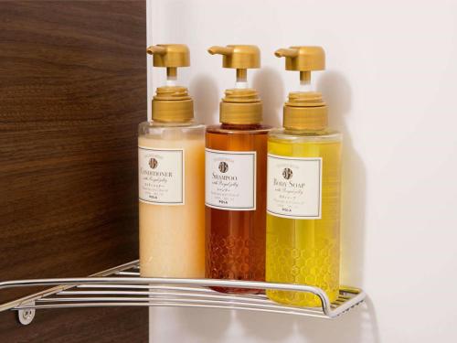 three bottles of oils are sitting on a shelf at KOKO HOTEL Hidatakayama - formaly Hotel Wing Hida Takayama in Takayama
