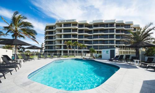 a large hotel with a swimming pool in front of it at San Simeon Beachfront Apartments Tugun in Gold Coast