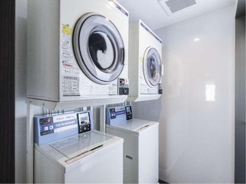 a laundry room with two washing machines and a washer at Hotel Wing International Hida Takayama in Takayama