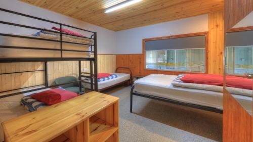 a bedroom with two bunk beds and a desk at Anglers Reach Lakeside Village in Anglers Reach
