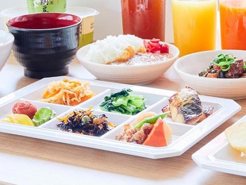a plate of food on a table with bowls of food at KOKO HOTEL Hidatakayama - formaly Hotel Wing Hida Takayama in Takayama