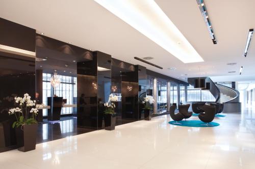 a lobby with escalators and flowers in a building at Radisson Blu Hotel, Hamburg in Hamburg