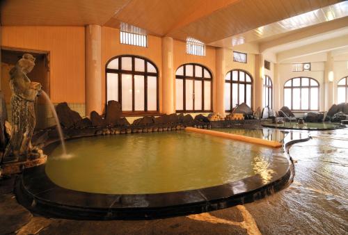 a large room with a water fountain in the middle of it at Tokiwaya in Nozawa Onsen