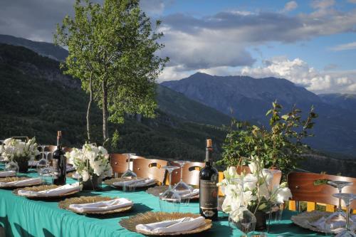 a table with a green table cloth and wine bottles at Chestnut Hill in Kolgecaj