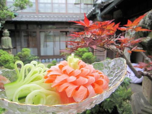 a bowl of noodles with a flower in it at Ryokan Taishoro in Sakurai