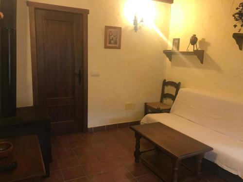 a bedroom with a bed and a table and a door at Casa Rural Cortijo La Ajedrea in Siles