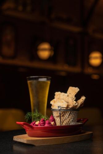 a glass of beer and a plate of food with a drink at The Residency Towers Puducherry in Puducherry