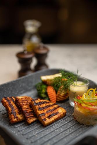 a plate of food with meat and vegetables on a table at The Residency Towers Puducherry in Puducherry