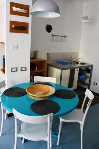 a kitchen with a blue table and white chairs at Da Marcella in Vernazza