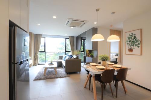 a dining room and living room with a table and chairs at Alix Bangkok Hotel in Bangkok