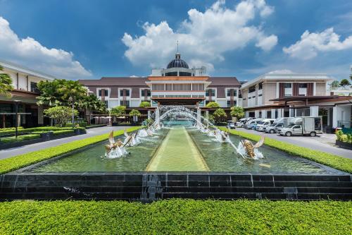 a fountain in front of a building with ducks in the water at Summit Windmill Golf Residence in Bangna