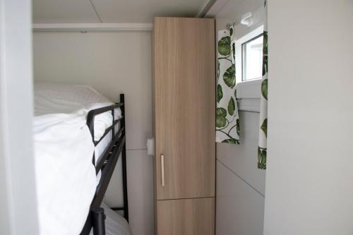 um pequeno quarto com um beliche e um closet em Houseboat uitzicht over veluwemeer, natuurlokatie, prachtige vergezichten em Biddinghuizen