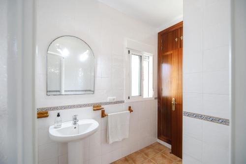 Un baño blanco con lavabo y espejo. en Los paraisos 1, en Conil de la Frontera