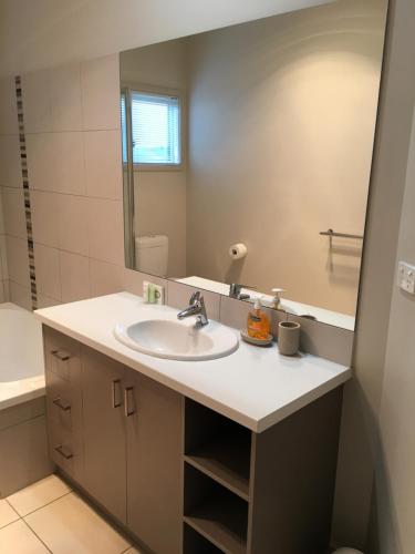 un bagno con lavandino e specchio di luxury abalina cottages a Bright
