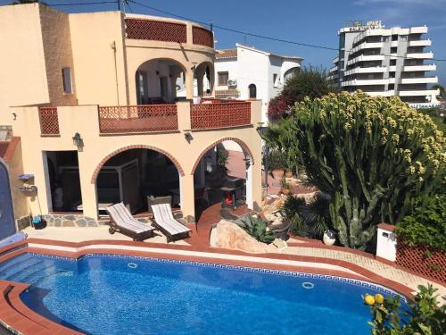 a swimming pool in front of a house at Villa Vid-Bil Calpe in Calpe