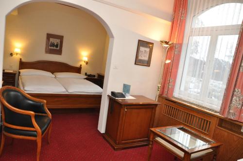 a bedroom with a bed and a chair and a window at Soldanella in St. Moritz