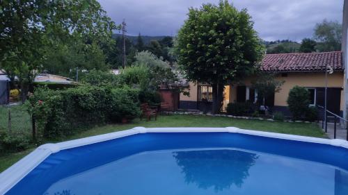 a large blue swimming pool in a yard with a house at Vila Graugés in Ripoll