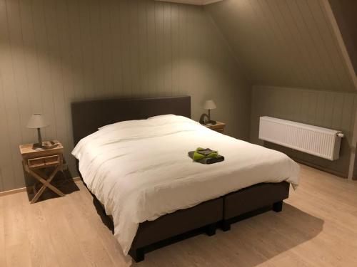 um quarto com uma grande cama branca com um laço em B&B De Dulle Koe em Waregem