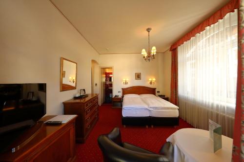 a hotel room with a bed and a television at Soldanella in St. Moritz