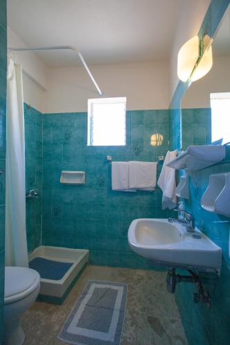 a bathroom with a sink and a toilet and a tub at Stella's Apartments in Tolo