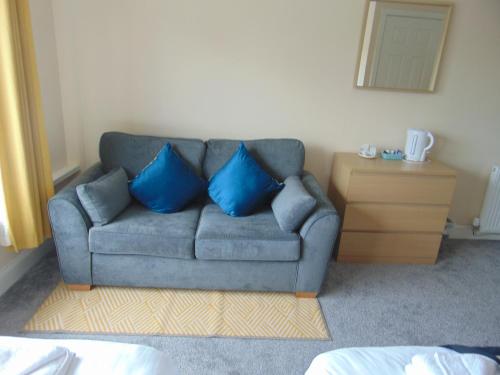 a couch with two blue pillows in a room at Callander Hostel in Callander