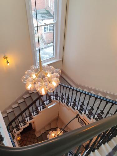 una escalera con una lámpara de araña frente a una ventana en Apartment 6 Rowntree House, en York