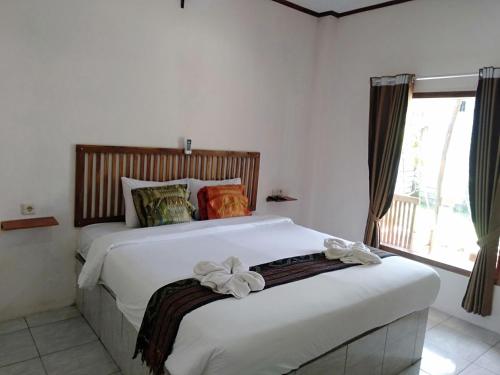 a bedroom with two beds and a window at Jeri Home Stay in Kuta Lombok