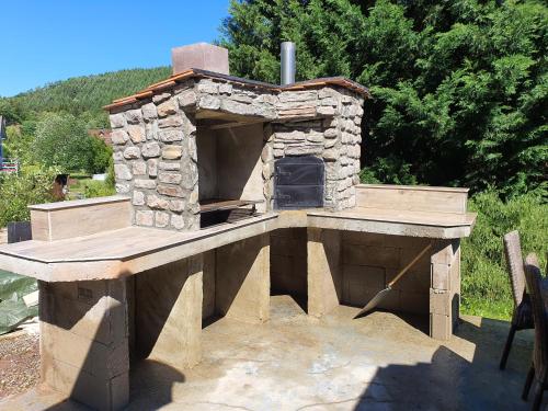 an outdoor pizza oven sitting on top of a deck at Chalet du champs des semeaux in Wisches