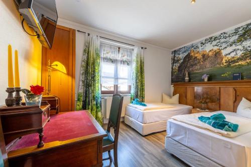 UsingenにあるLandgasthof Eschbacher Katzのベッド2台とデスクが備わるホテルルームです。