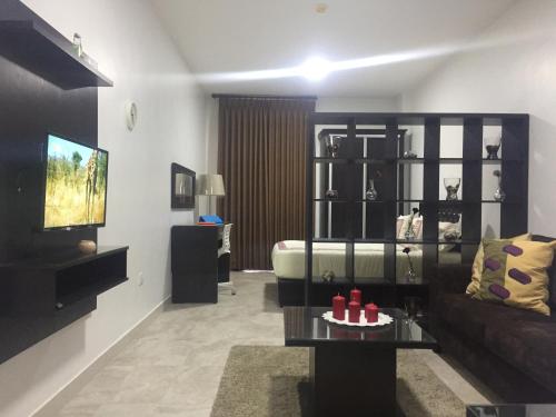 a living room with a couch and a tv at Tunaib Plaza in Aţ Ţunayb