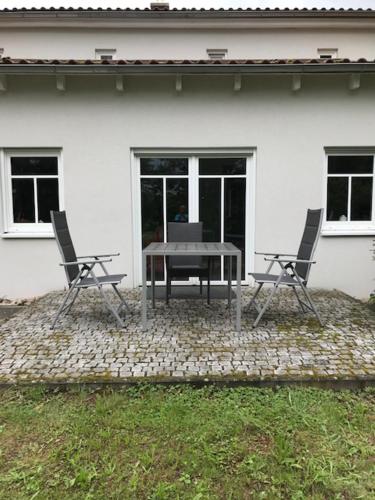2 chaises et une table en face d'une maison dans l'établissement Friedensoase, à Ebensfeld