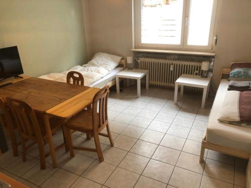 uma sala de estar com uma mesa e uma cama em Wohnung 4 em Alzenau in Unterfranken