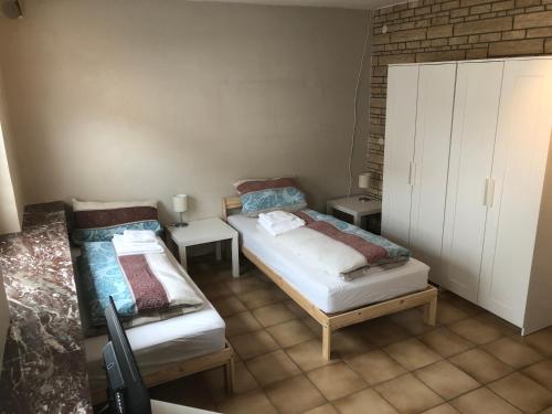 um pequeno quarto com 2 camas e um armário em Wohnung 4 em Alzenau in Unterfranken