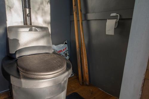 a bathroom with a toilet and a trash can at Lingonberry Pieni mökki saunalla in Mikkeli