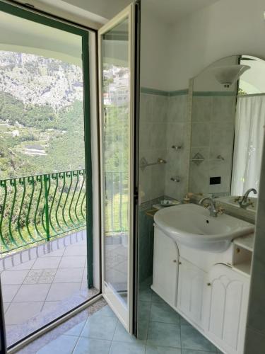 a bathroom with a sink and a sliding glass door at Gerry house in Amalfi