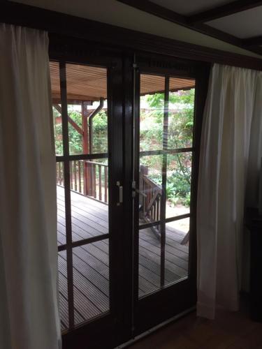 an open door to a deck with white curtains at Mijn Chalet in Erm