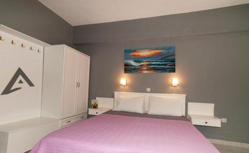 a bedroom with a bed with a purple blanket at Alpha Studios in Arkasa