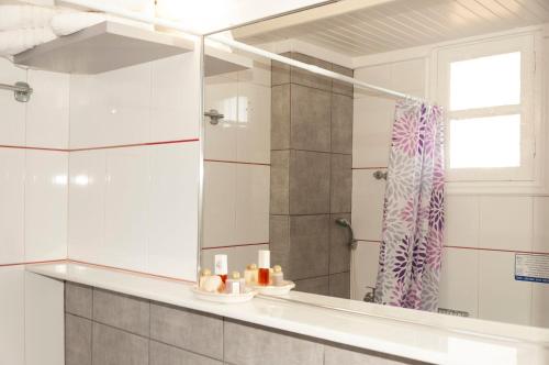 a bathroom with a shower and a large mirror at Alpha Studios in Arkasa