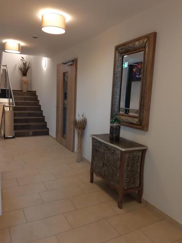 a hallway with a mirror and a table and stairs at Rossano Boutique Hotel & Ristorante in Ansbach