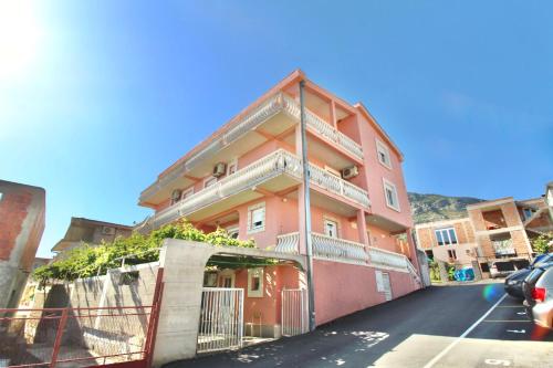 a pink building with balconies on the side of a street at Apartments Mušović in Bar