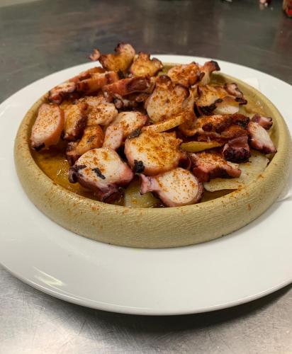a bowl of food on a white plate at Hostal Tarrés in Anglés